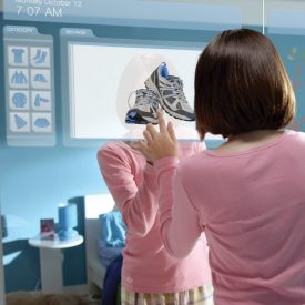 一位女士使用嵌入臥室衣櫃門的大型觸控式螢幕顯示器